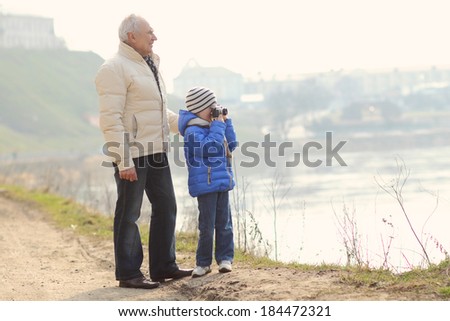 Grandfather and grandson are photographed on a vintage camera. Grandfather and grandchild