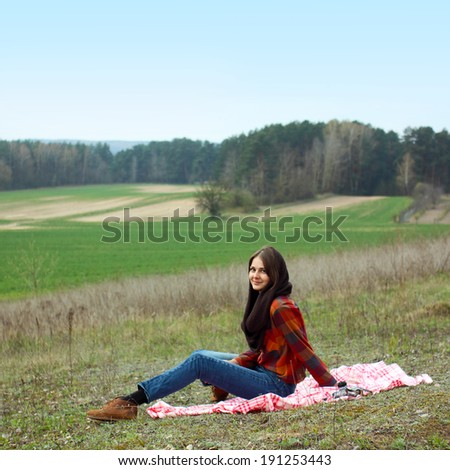 beautiful young girl hipster dreams of lying on a magic meadow in spring. Hipster beautiful girl with the camera in a field in spring