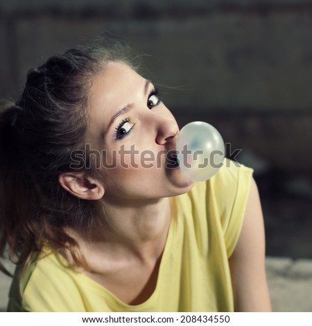 Beautiful  girl inflating bubble of chewing gum. modern hipster girl.  Outdoors, lifestyle.