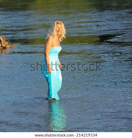 mature beautiful blonde in vintage dress having fun in the sea. romantic portrait of an elderly woman