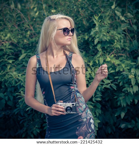 Modern hipster girl photographed vintage camera outdoors. Lifestyle outdoor portrait. in vintage colors