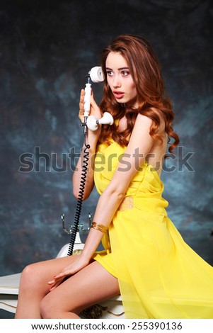 Pin-up girl talking on retro telephone. beautiful young girl with a vintage telephone survey in retro style