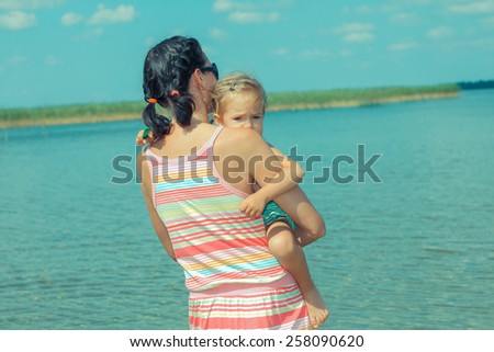 Mom and daughter at the hands enter the water