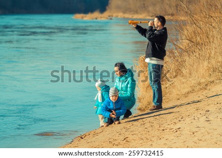 young family looks into the distance through a spyglass