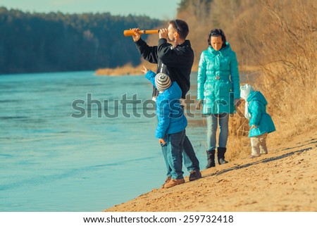 young family looks into the distance through a spyglass