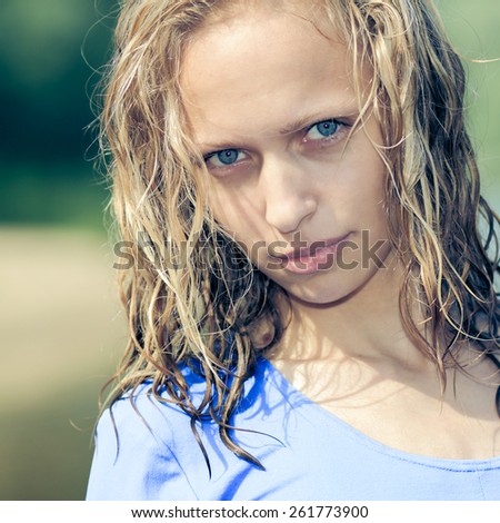 Portrait of a cheerful pleasant blonde girl with blue eyes and wet hair