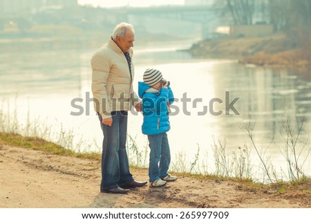Grandfather and grandson are photographed on a vintage camera. Grandfather and grandchild in a landscape