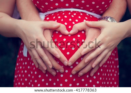 Pregnant woman with her hands on her belly