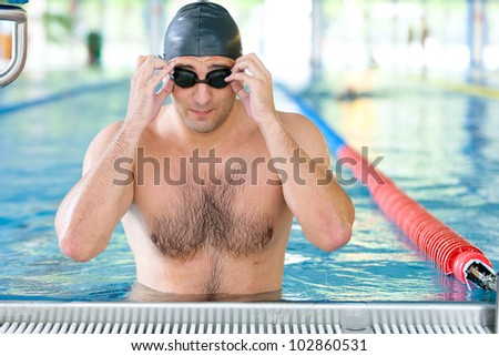 Male swimmer getting ready for laps in indoor pool. training and sport concept