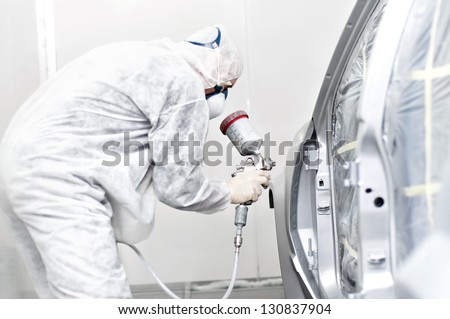 mechanical engineer working on painting a car in a painting booth