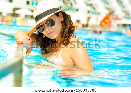 Sexy woman in bikini enjoying a hot summer day in private pool at tropical resort on the beach