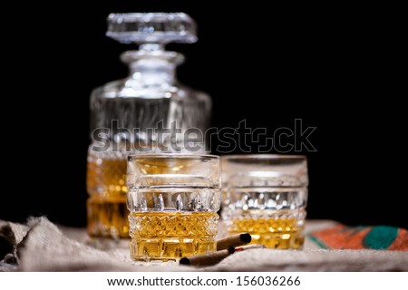 Whiskey and scotch drinks on wood with bar bottle on background isolated on black