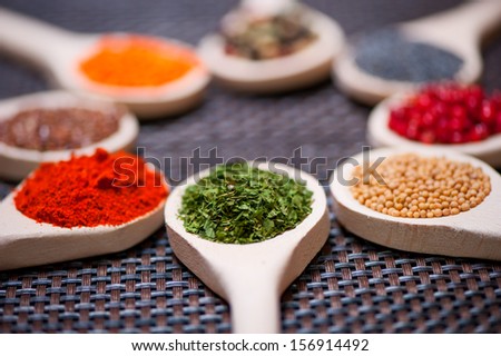 Various kind of spices on wooden spoon -  detail of chopped and dried parsley