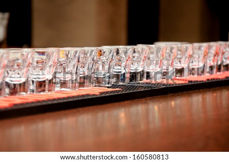 Alcoholic drink in small glasses on the bar in party nightclub waiting to be served