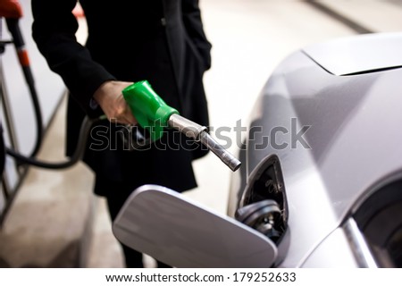Woman pumping gas at petrol station