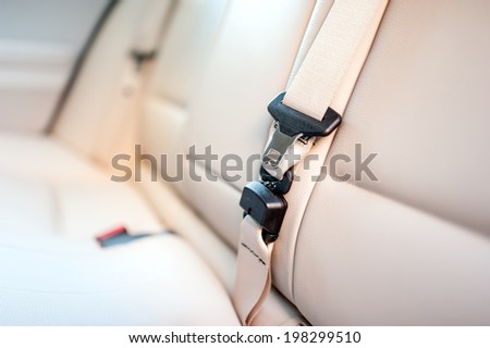 Seat belt on rear seat of modern car with beige leather interior