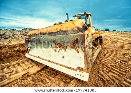 close-up of bulldozer blade, industrial machines working in sandpit on construction site