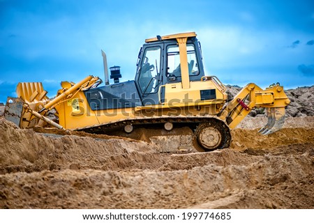 bulldozer or excavator working with soil on construction site of building, road or industrial hall