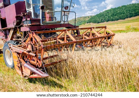 close-up of wheat harvesting machinery. Agricultural activities - crops production with industrial combine