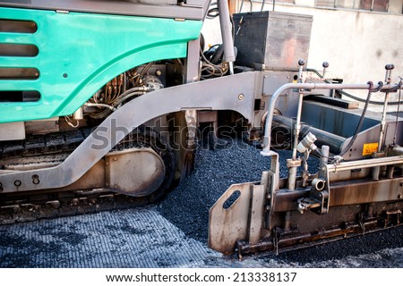 Industrial pavement truck or machine laying fresh bitumen and asphalt