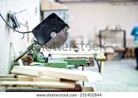industrial tool in wood and metal factory, compound mitre saw with sharp, circular blade