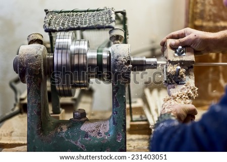 worker hands using wood-turning tool and other industry tools for creating wooden objects and furniture