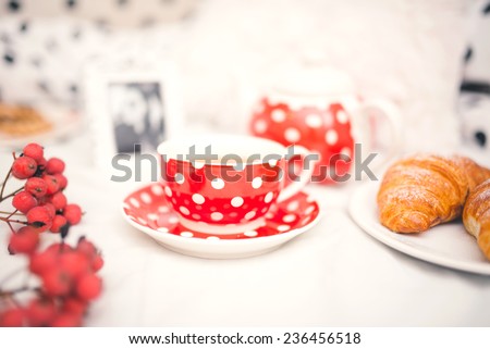 Closeup of red dots coffee cup and croissants as breakfast