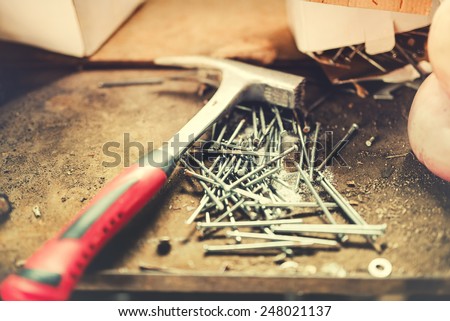 Construction tools, carpentry hammer and nails in work shop. Soft effect on photo