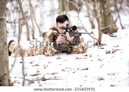 Hunter shooting with a sniper rifle, aiming and firing bullets