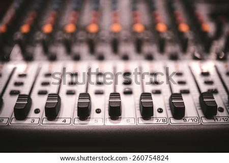 Sound studio recording equipment, music mixer controls at concert or party in a night club. Soft effect on photo