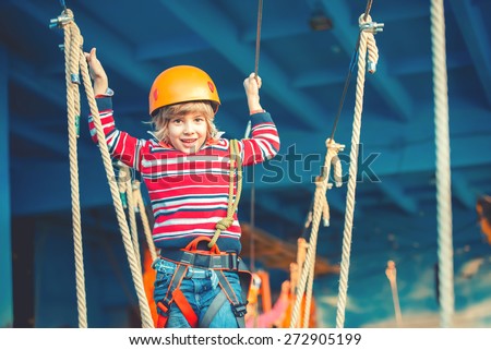 Happy childhood concept - boy playing and exploring activities at park