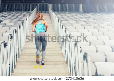 Active female runner enjoying a workout, training and working out. Fitness girl jogging on stairs
