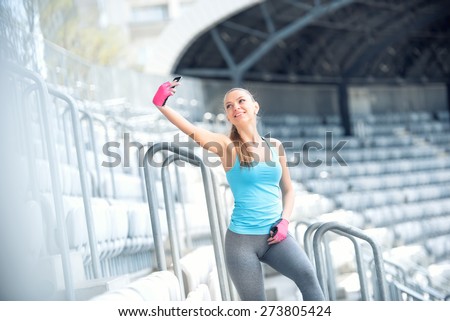 Portrait of a beautiful young woman selfie with a smartphone. Modern concept of fitness life