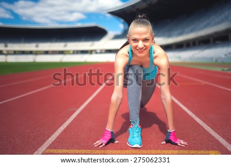 Active female runner preparing for a track contest, enjoying a workout, training and working out. Fitness girl jogging on stadium track. Instagram filter effect