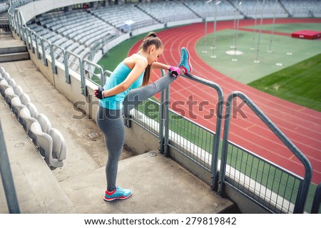 Female athlete training and stretching for warming up on the stairs. Fitness girl training and running