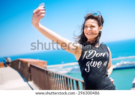Loving to take pictures of herself, girl smiling and being happy while making selfie.