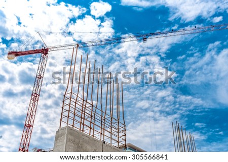 Industrial concrete wall with reinforced steel closeup, crane and building site of buildings