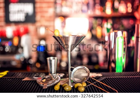 alcoholic drink on bar counter. Dry martini with ice and olives, served cold in restaurant, bar or pub.
