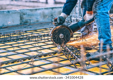 industrial details with worker cutting steel bars and reinforced steel with angle grinder. Filtered image