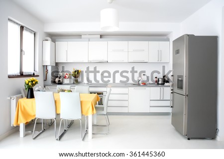 Interior design, modern and minimalist kitchen with appliances and table. Open space in living room, minimalist decor