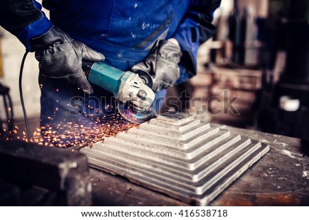 industrial engineer working on cutting a metal and steel bar with angle grinder, metallurgic factory details
