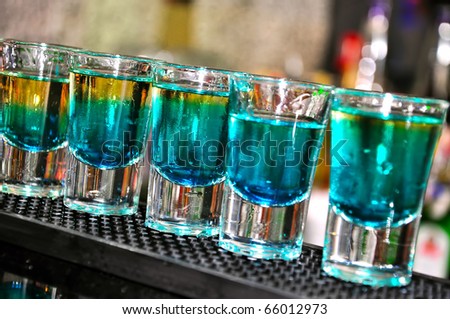 Blue drink in shot glasses standing on the counter