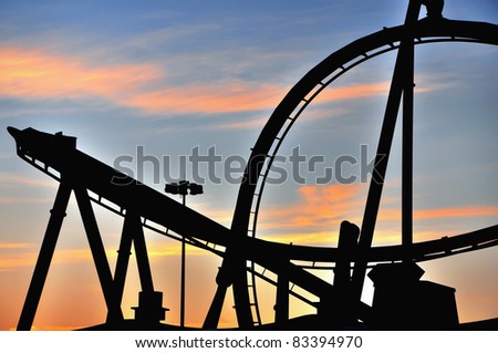 Sunset silhouette of a roller coaster in a theme amusement park