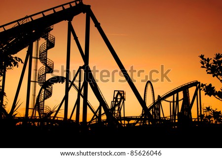 silhouette of a roller coaster during sunset at a fun fair