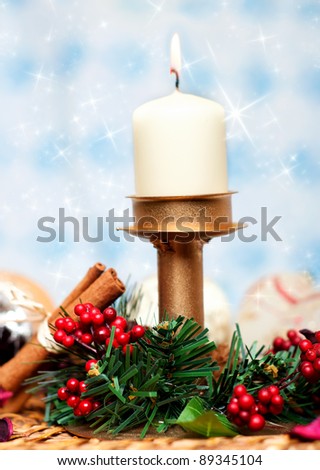 Christmas branch with berries, cinnamon sticks and candle for a wonderful christmas decor