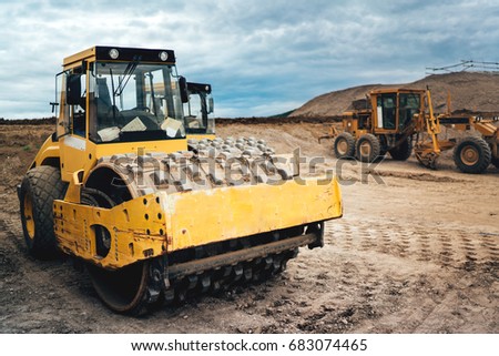 heavy duty machinery working on highway construction site. Bulldozer, dumper truck, soil compactor and vibratory roller