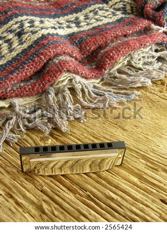 Harmonica on weathered wood background with Western-style blanket