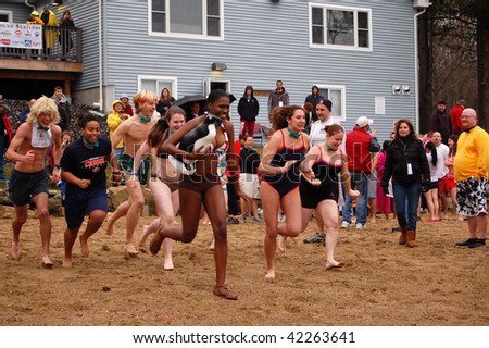 COVENTRY, CT - DECEMBER 5: A group of brave volunteers run toward icy lake water to raise money for the Special Olympics at a \