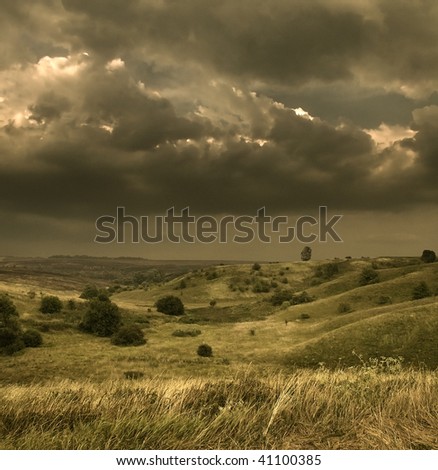 Low clouds preceding a storm Storm presentiment The hills covered with a grass