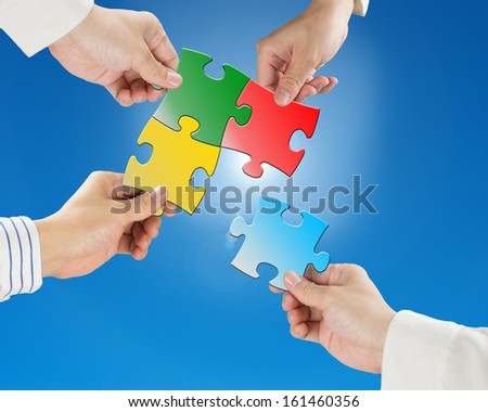 Team work concept, Hands hold puzzles with clear blue sky and sun light background